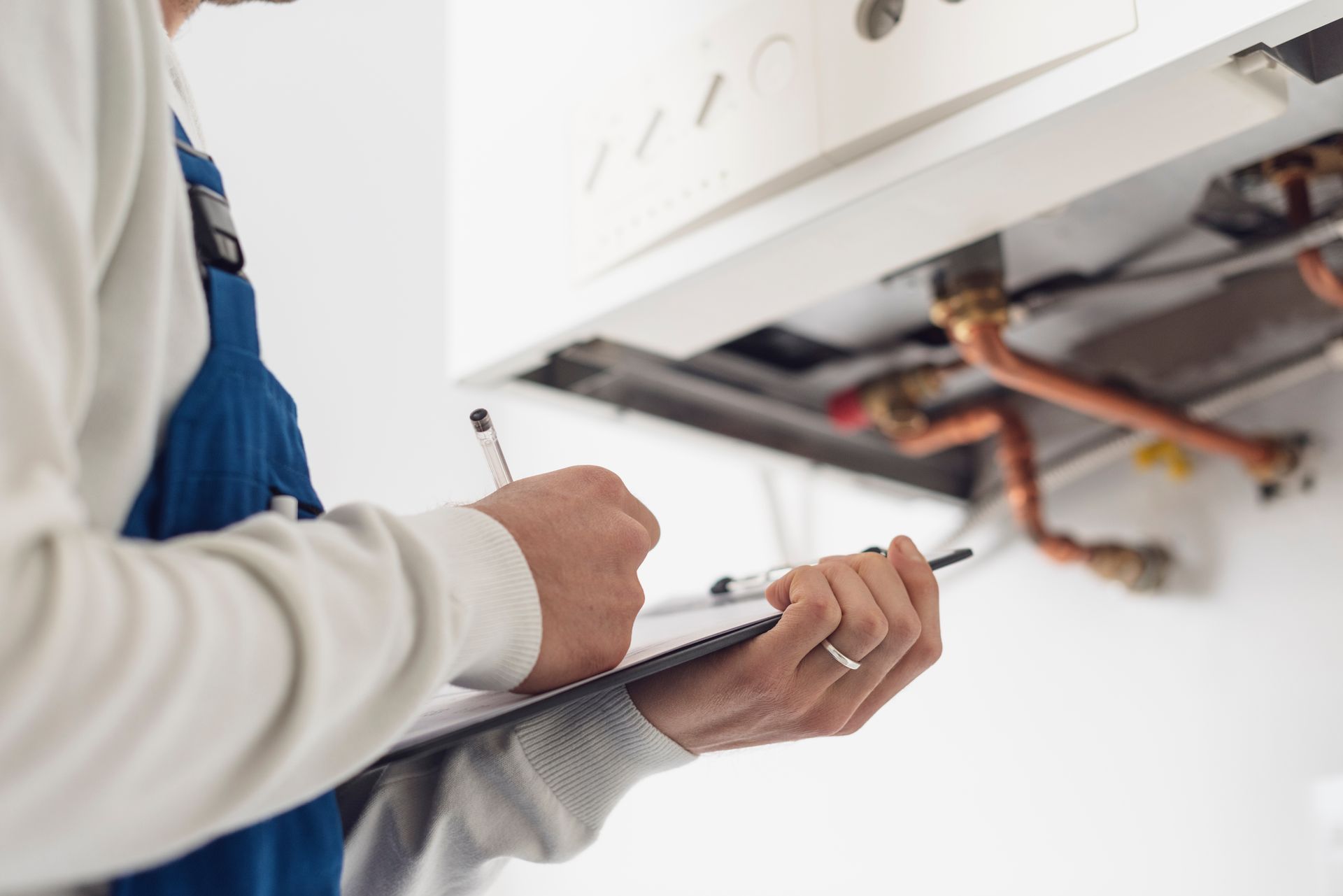 Un technicien rédige un rapport de contrat de maintenance d'une chaudière