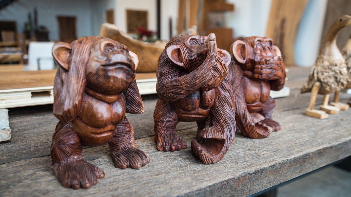 Geschnitzte Holzfiguren als Kunstobjekte im Außenbereich.