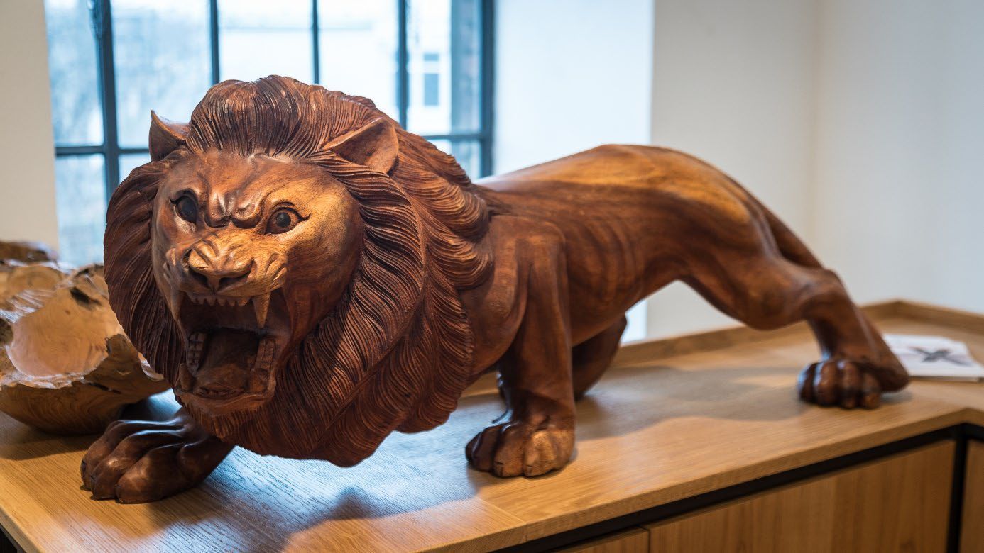 Detailreiche Holzskulptur in Tierform auf Werkbank.