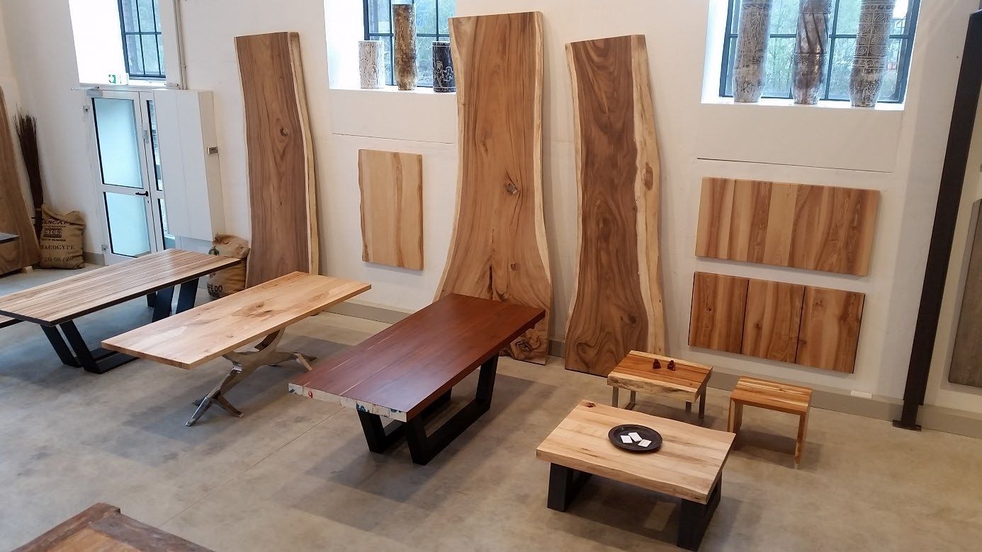 Ausstellung handgefertigter Holzmöbel in einem Raum.