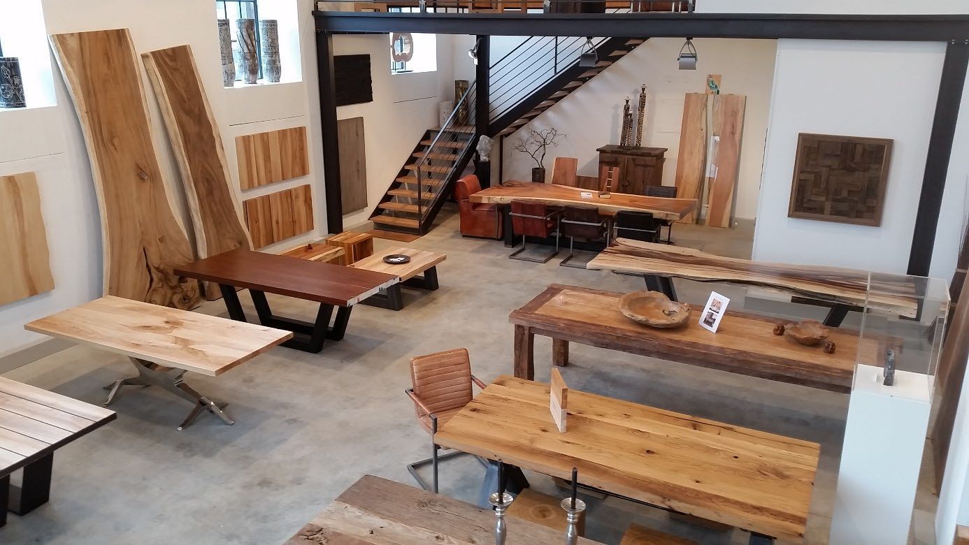 Große Werkstatt mit langen Holztischen und Ausstellungsstücken.