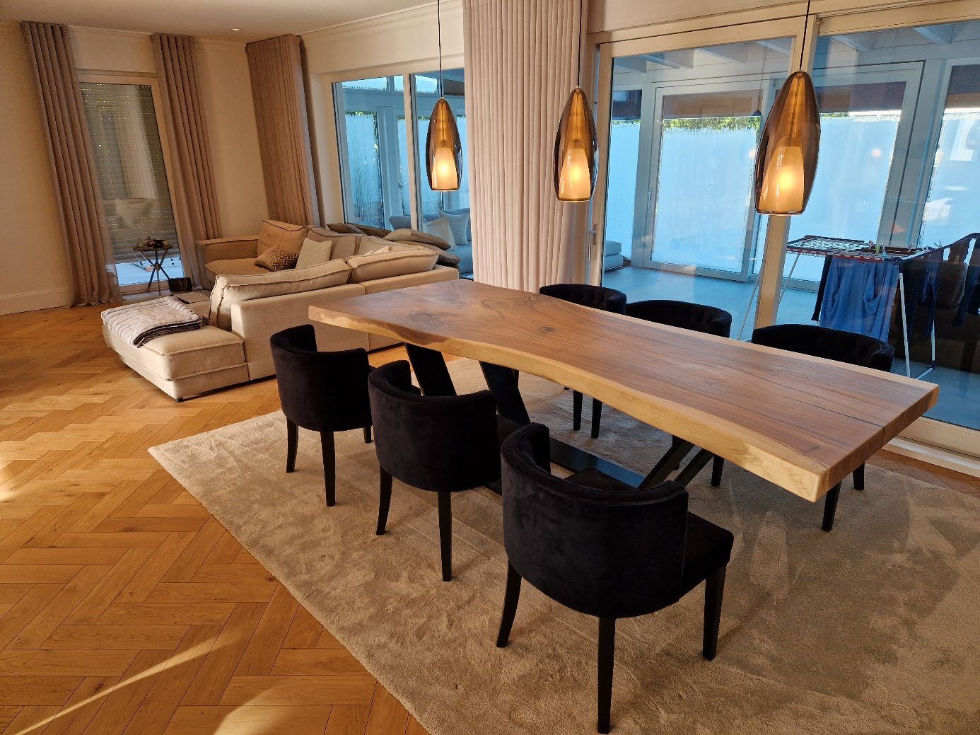 Moderner Essbereich mit großem, naturbelassenem Holztisch und schwarzen Stühlen