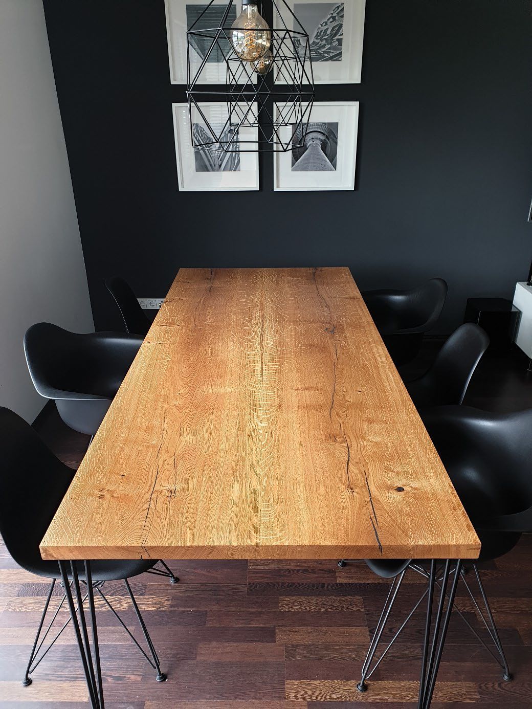 Moderner Holztisch mit sichtbarer Maserung und schwarzen Metallbeinen