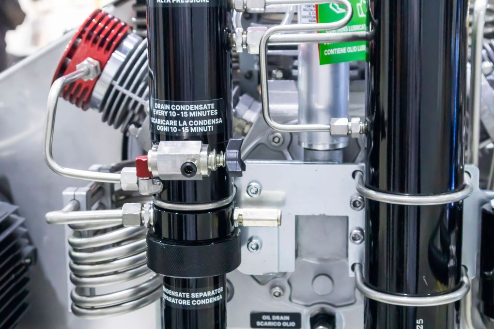 Gros plan sur des machines industrielles avec des tuyaux métalliques, des vannes et des flexibles dans une usine.