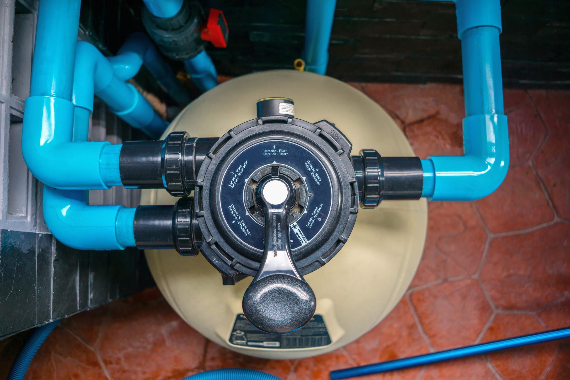 Équipement de filtration avec des tuyaux et une vanne centrale sur une cuve.