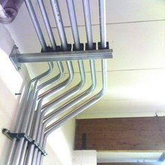 Elektrische Metallrohre, die in parallelen Reihen angeordnet und an einer Decke und einer Wand befestigt sind.