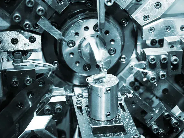Una máquina está cortando una pieza de metal en una fábrica.