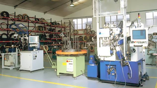 Una fábrica con mucha maquinaria y una línea amarilla en el suelo.