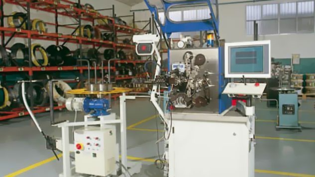 Una máquina está en un almacén al lado de una computadora.