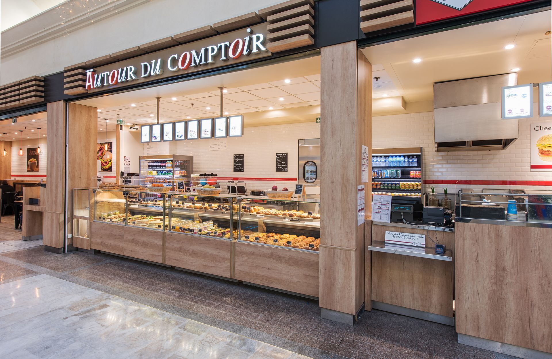 La façade d'une boulangerie Autour du Comptoir dans un centre commercial, avec un comptoir vitré rempli de pâtisseries.