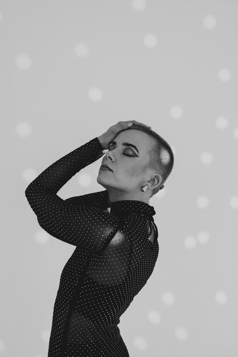 Ein Schwarzweißfoto einer Frau mit rasiertem Kopf.