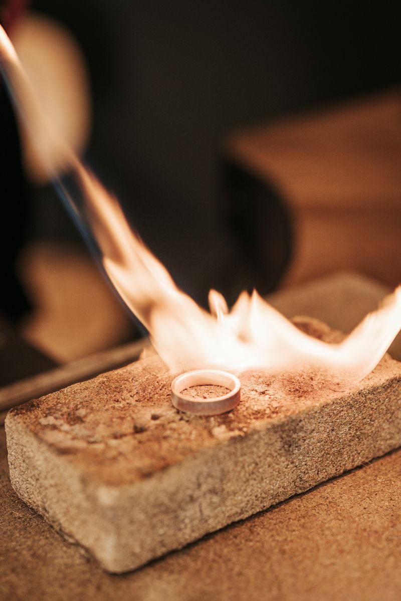 Ein Ring wird mit einer Fackel auf einem Ziegelstein erhitzt.