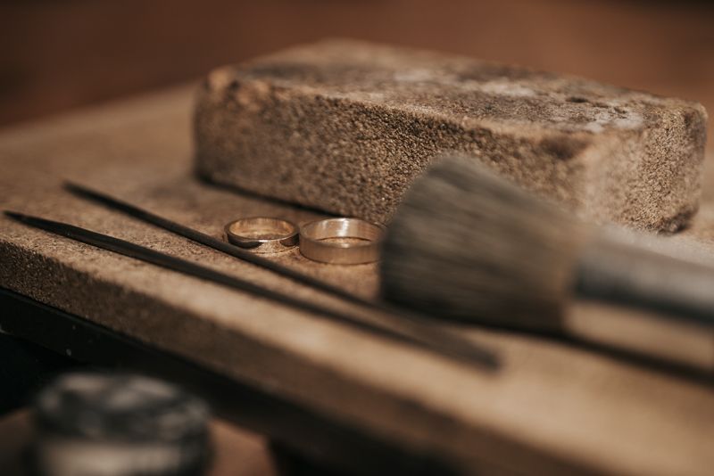 Ein paar Eheringe liegen auf einem Holztisch.