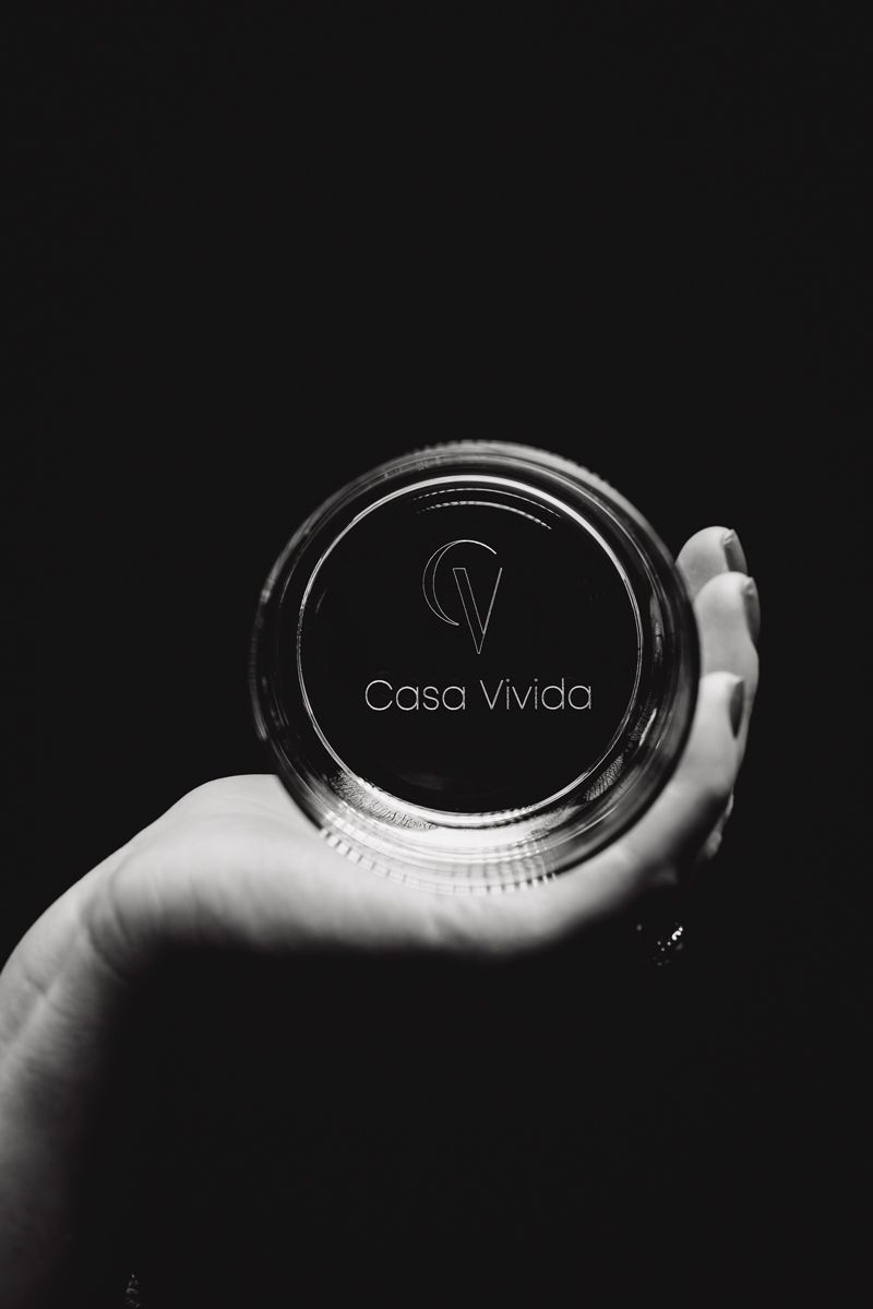 Ein Schwarzweißfoto einer Person, die ein Glas in der Hand hält.