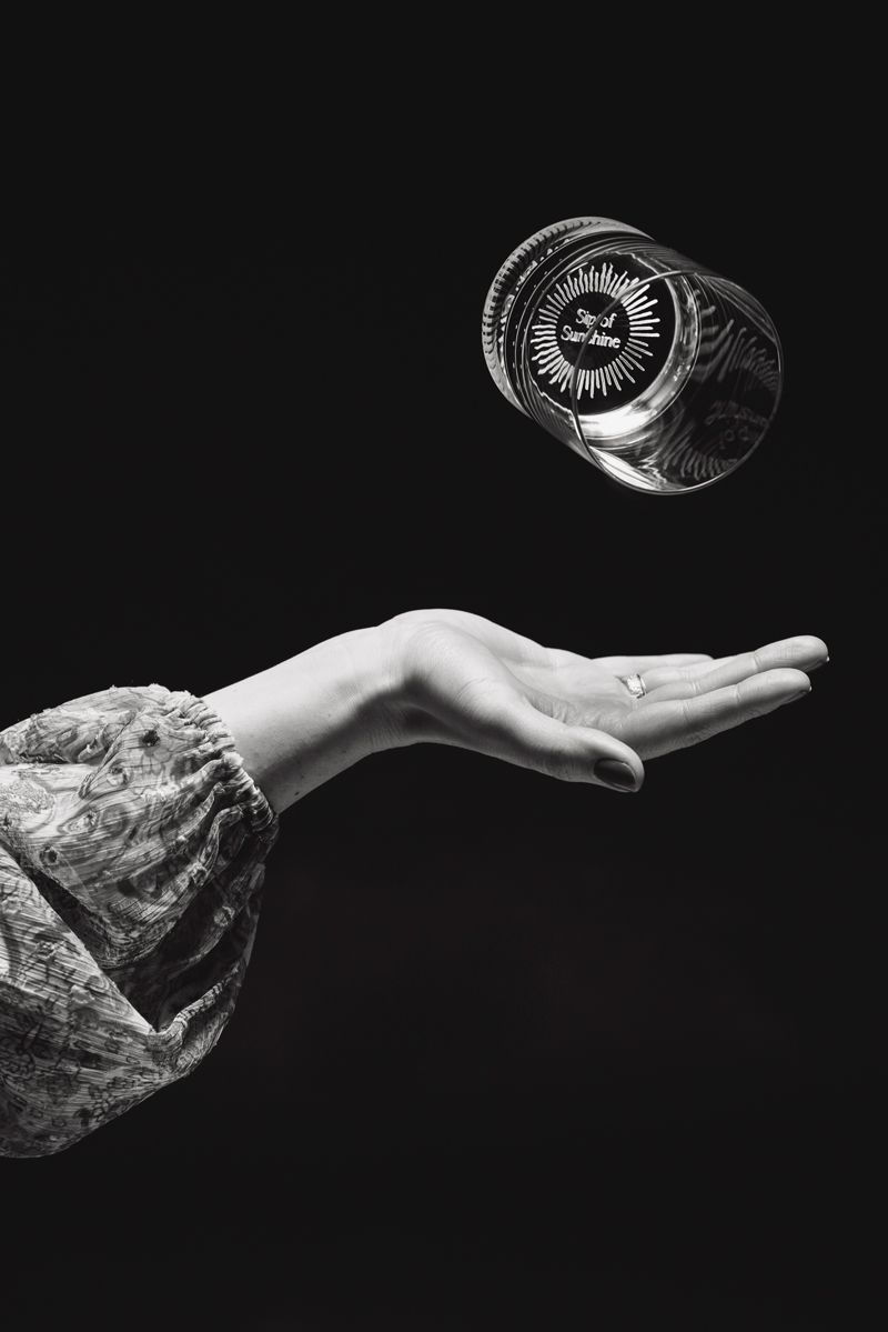 Ein Schwarzweißfoto einer Person, die ein Glas in die Luft wirft