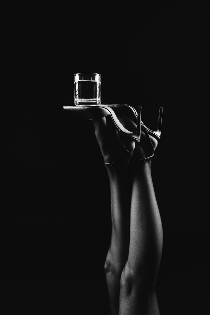 Eine Frau hält ein Glas Whiskey auf einem Tablett.