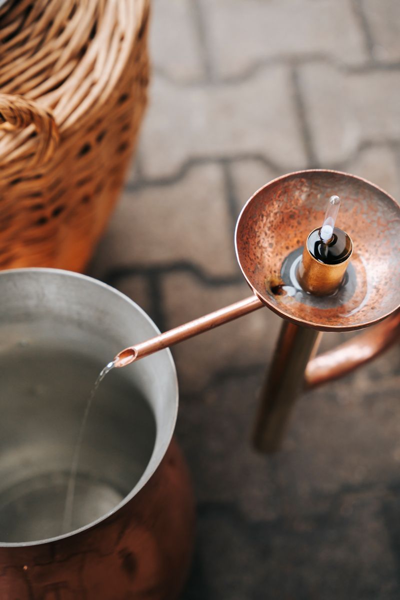 Ein Topf Wasser wird in einen Kupfertopf gegossen.