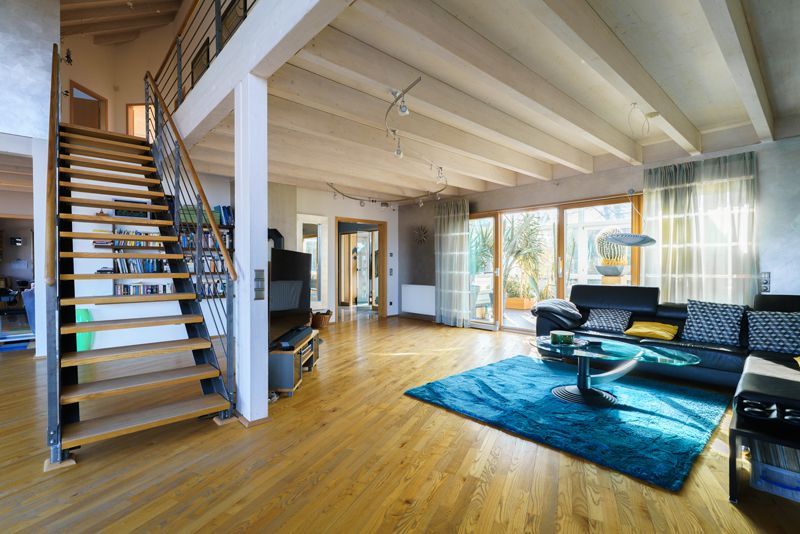 Ein Wohnzimmer mit einer Treppe, die in den zweiten Stock führt.