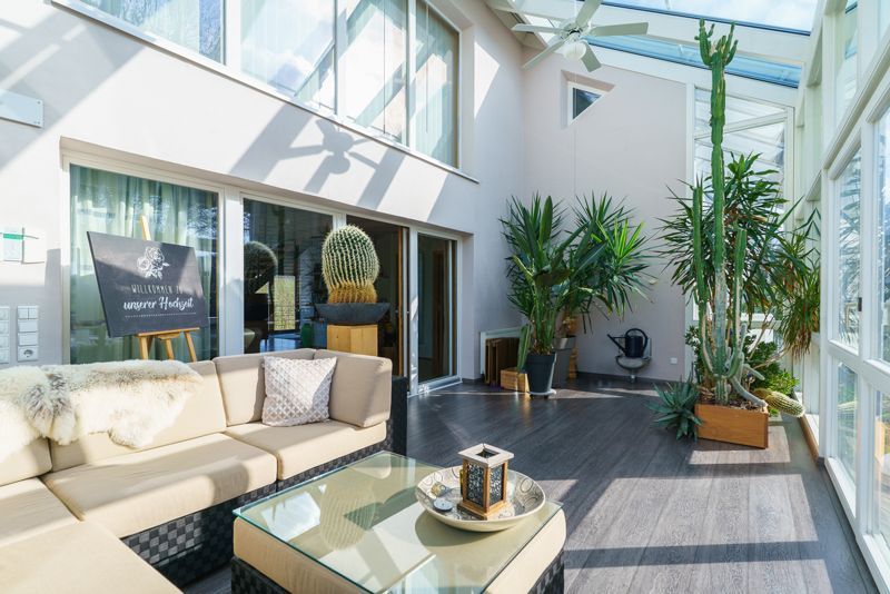 Ein Wohnzimmer mit Sofa, Tisch und Pflanzen.