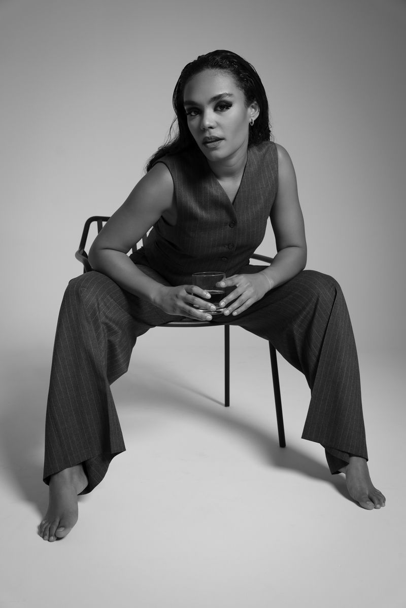 Ein Schwarzweißfoto einer Frau, die auf einem Stuhl sitzt