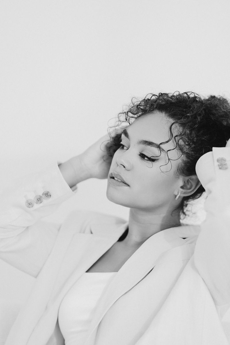 Ein Schwarzweißfoto einer Frau in einem weißen Anzug.