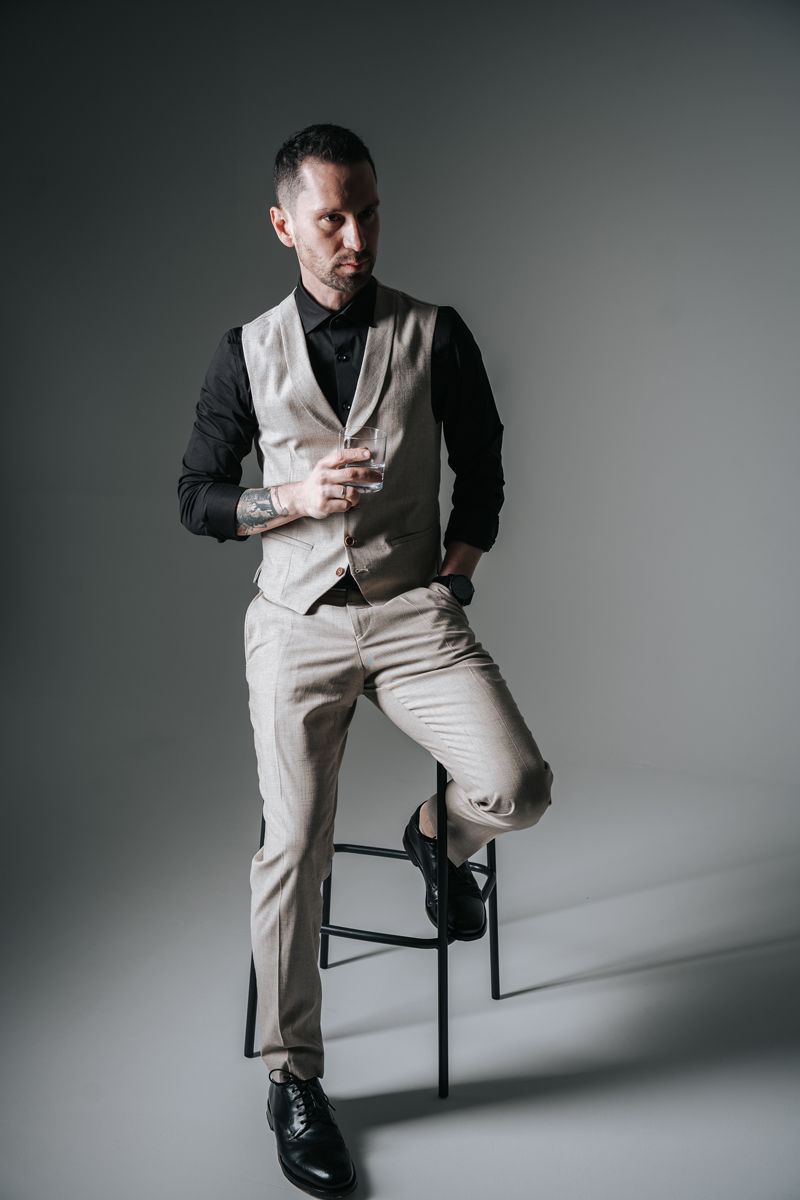 Ein Mann im Anzug sitzt auf einem Barhocker.