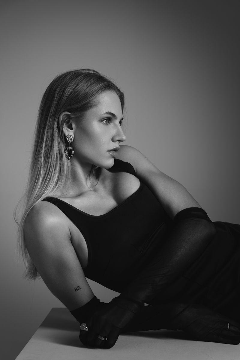 Ein Schwarzweißfoto einer Frau, die auf einem Tisch sitzt.