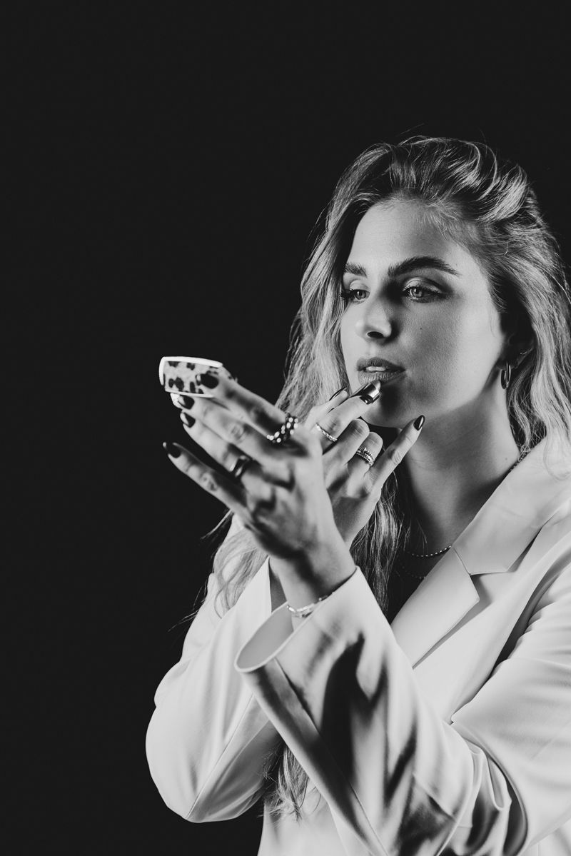 Ein Schwarzweißfoto einer Frau, die Lippenstift aufträgt.