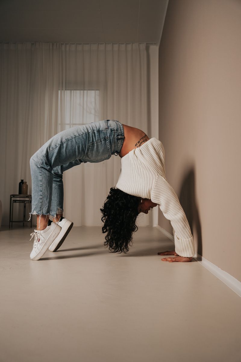 Eine Frau macht einen Handstand an einer Wand.