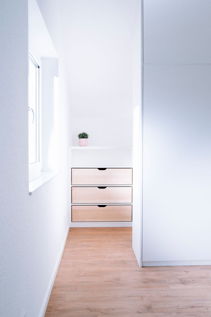 Mitten im Flur steht eine Kommode.