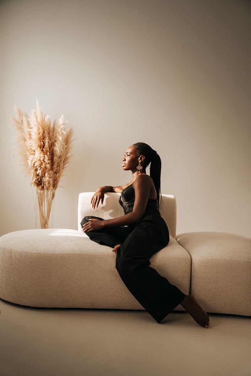 Eine Frau sitzt auf einem Sofa in einem Wohnzimmer.