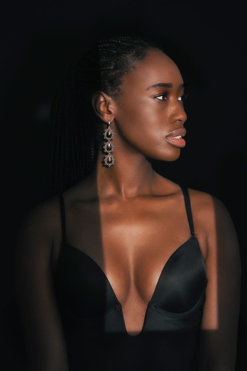 Die Frau trägt einen schwarzen BH und Ohrringe.