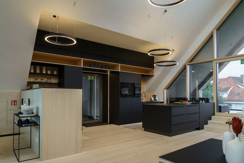 Eine Küche mit vielen Fenstern und schwarzen Schränken