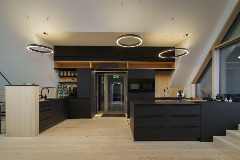 Eine Küche mit schwarzen Schränken und Holzböden