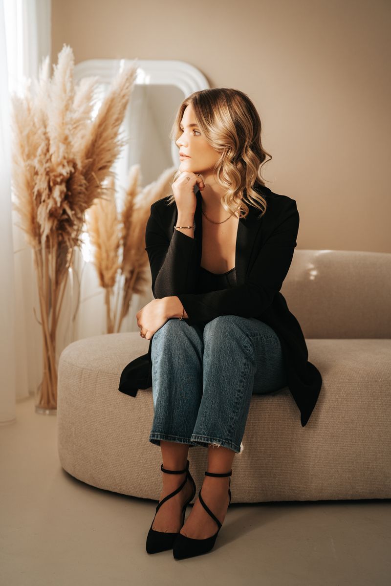 Eine Frau sitzt auf einem Sofa vor einem Spiegel.