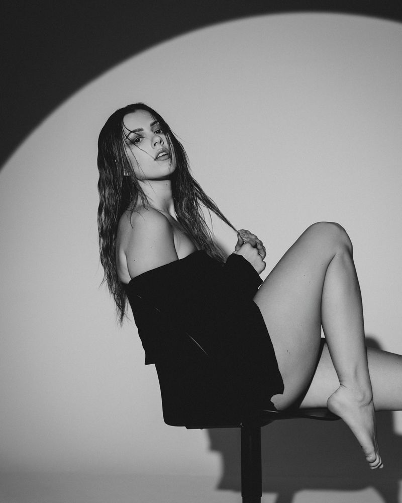 Ein Schwarzweißfoto einer Frau, die auf einem Stuhl sitzt