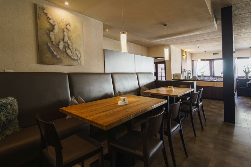 Ein Restaurant mit Tischen und Stühlen und einem Gemälde an der Wand.