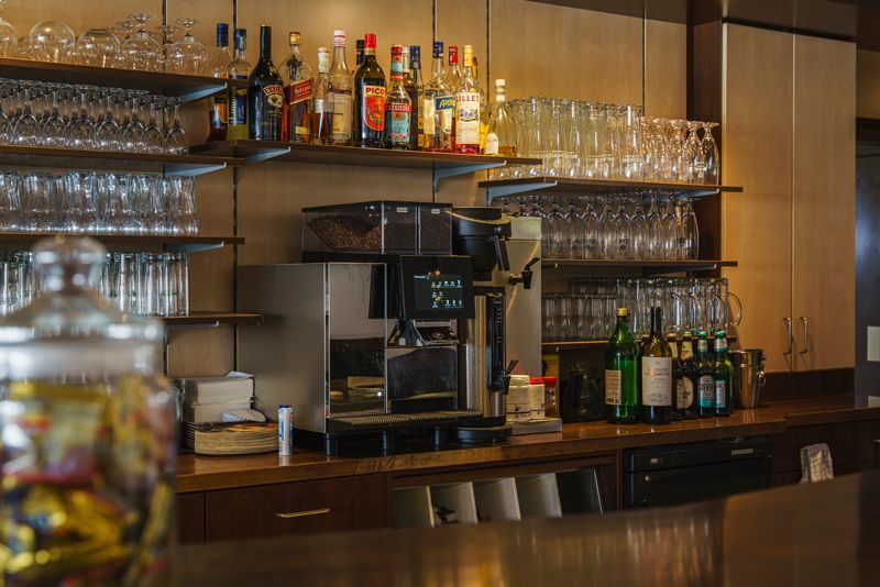 Eine Bar mit vielen Flaschen und Gläsern in den Regalen.