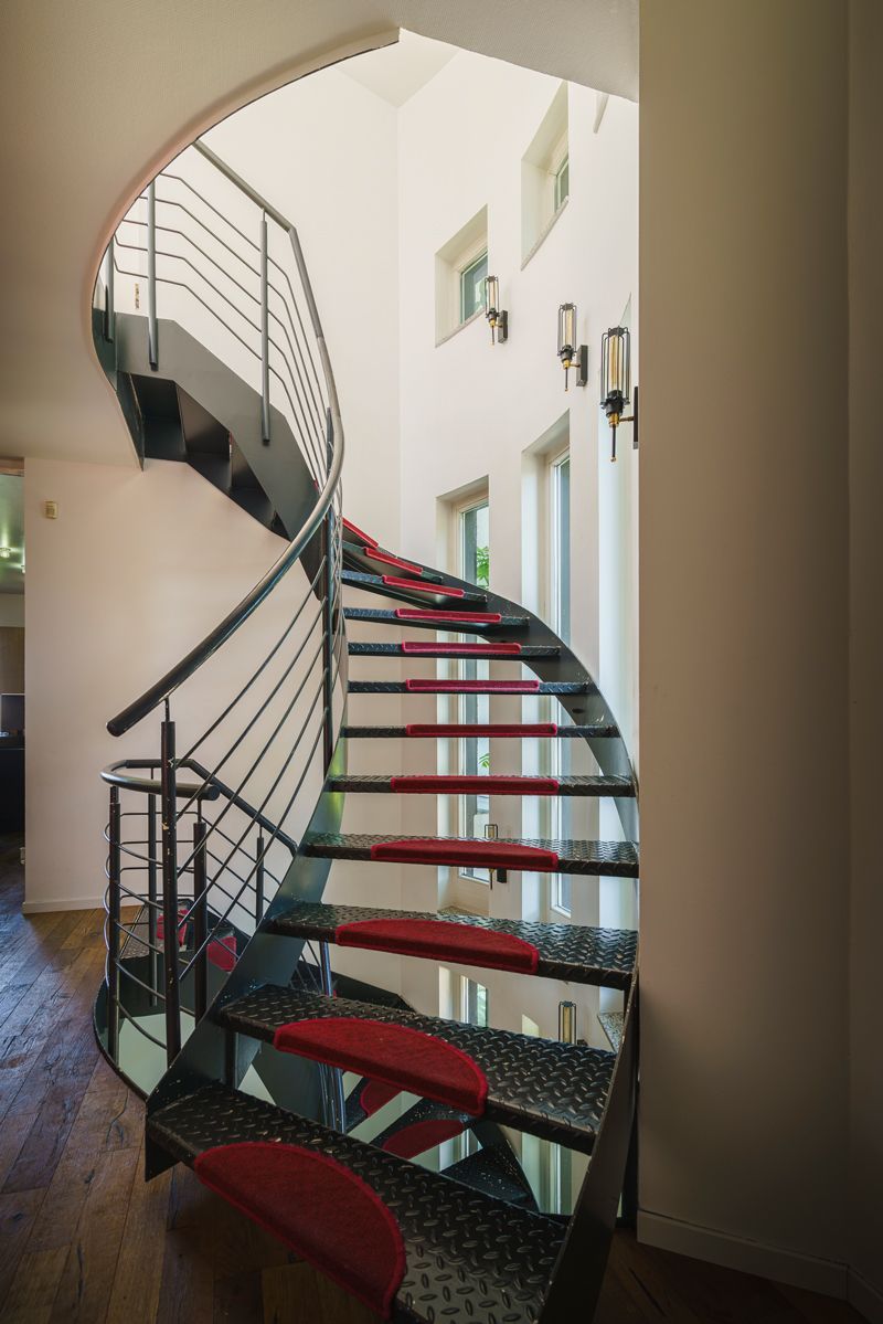 Eine Wendeltreppe mit roten Stufen in einem Haus