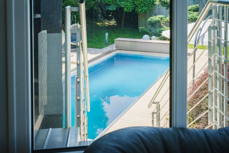Ein Blick auf einen Swimmingpool aus einem Wohnzimmerfenster.