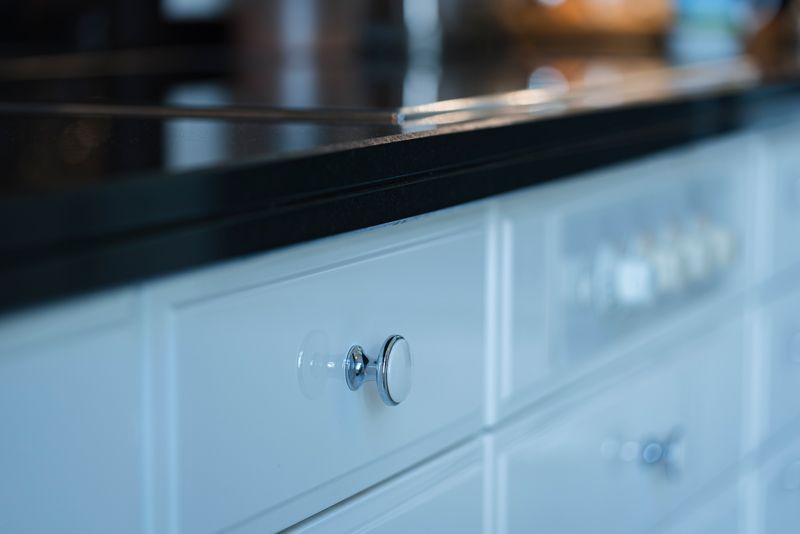 Eine Nahaufnahme einer Schublade in einer Küche mit einer schwarzen Arbeitsplatte.