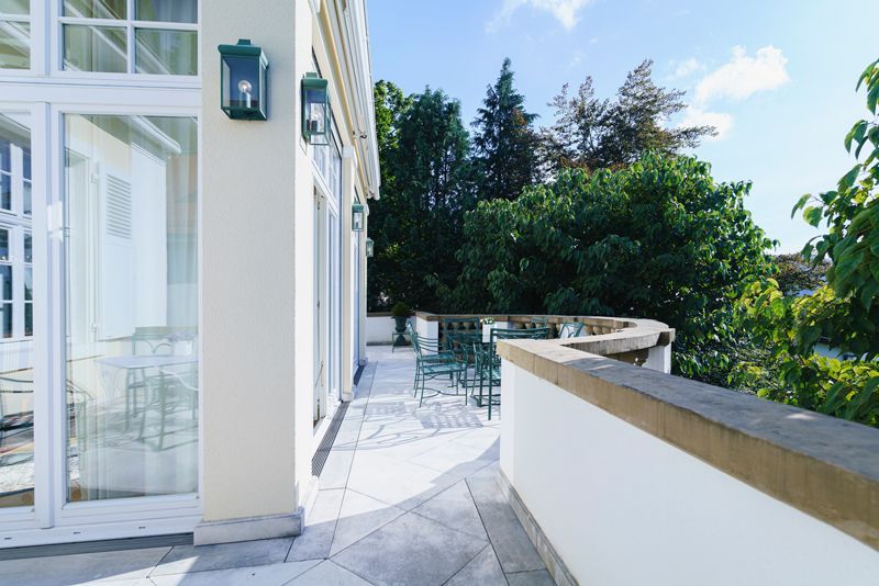 Ein Balkon mit Blick auf Bäume und blauen Himmel