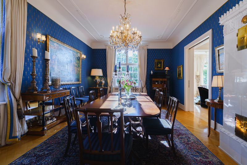 Ein Esszimmer mit einem langen Tisch und Stühlen und einem Kronleuchter.