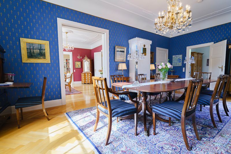 Ein Esszimmer mit Tisch, Stühlen und einem Kronleuchter.