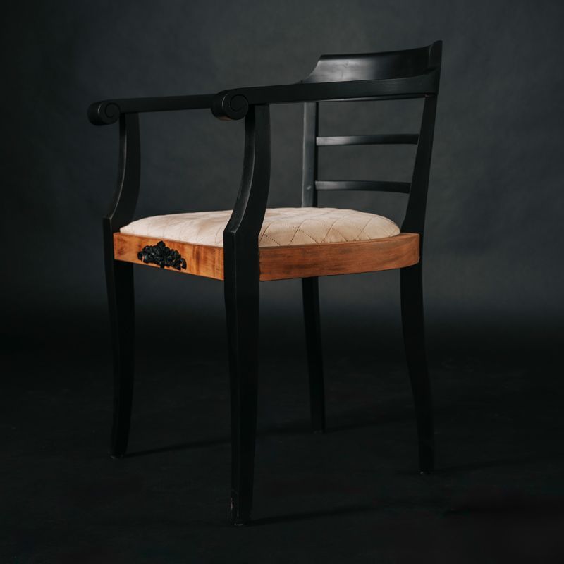 Ein schwarzer Holzstuhl mit einem weißen Kissen