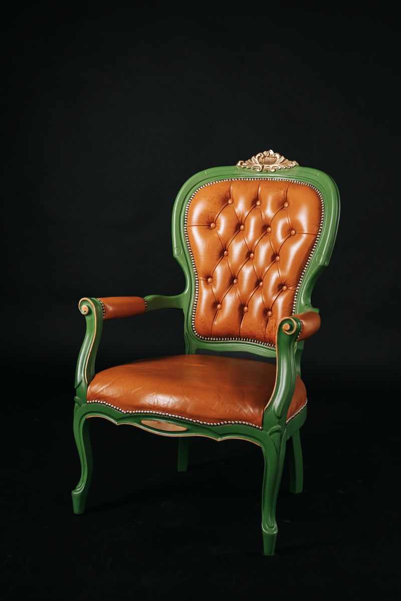 Ein grüner und orangefarbener Stuhl auf schwarzem Hintergrund.