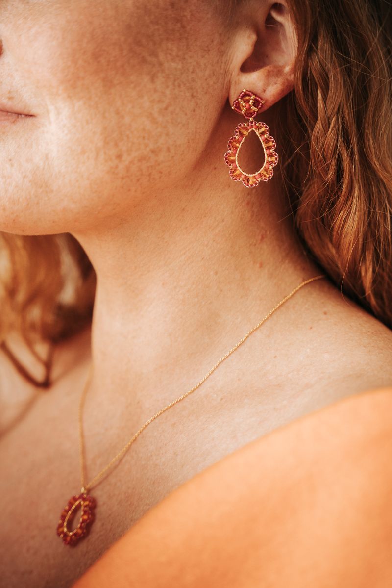 Eine Nahaufnahme einer Frau mit Ohrringen und einer Halskette.