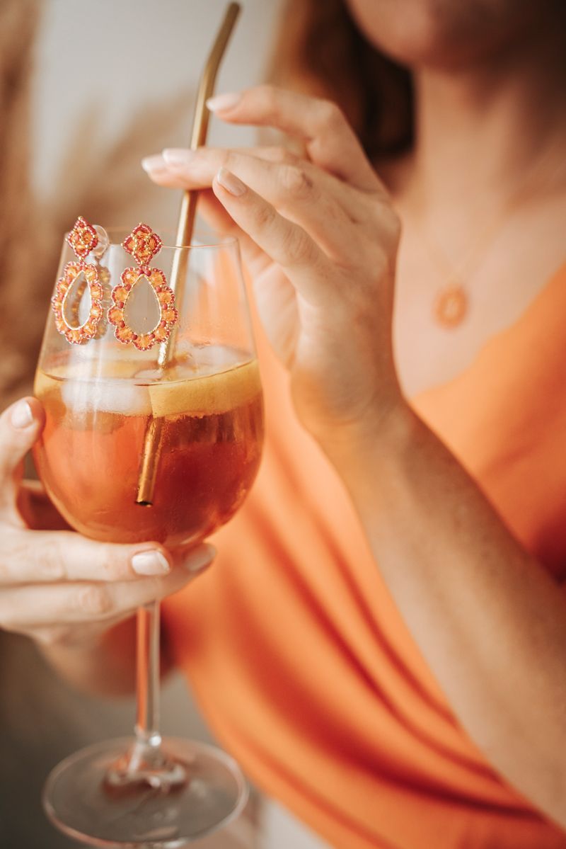 Eine Frau trinkt mit einem Strohhalm aus einem Glas.