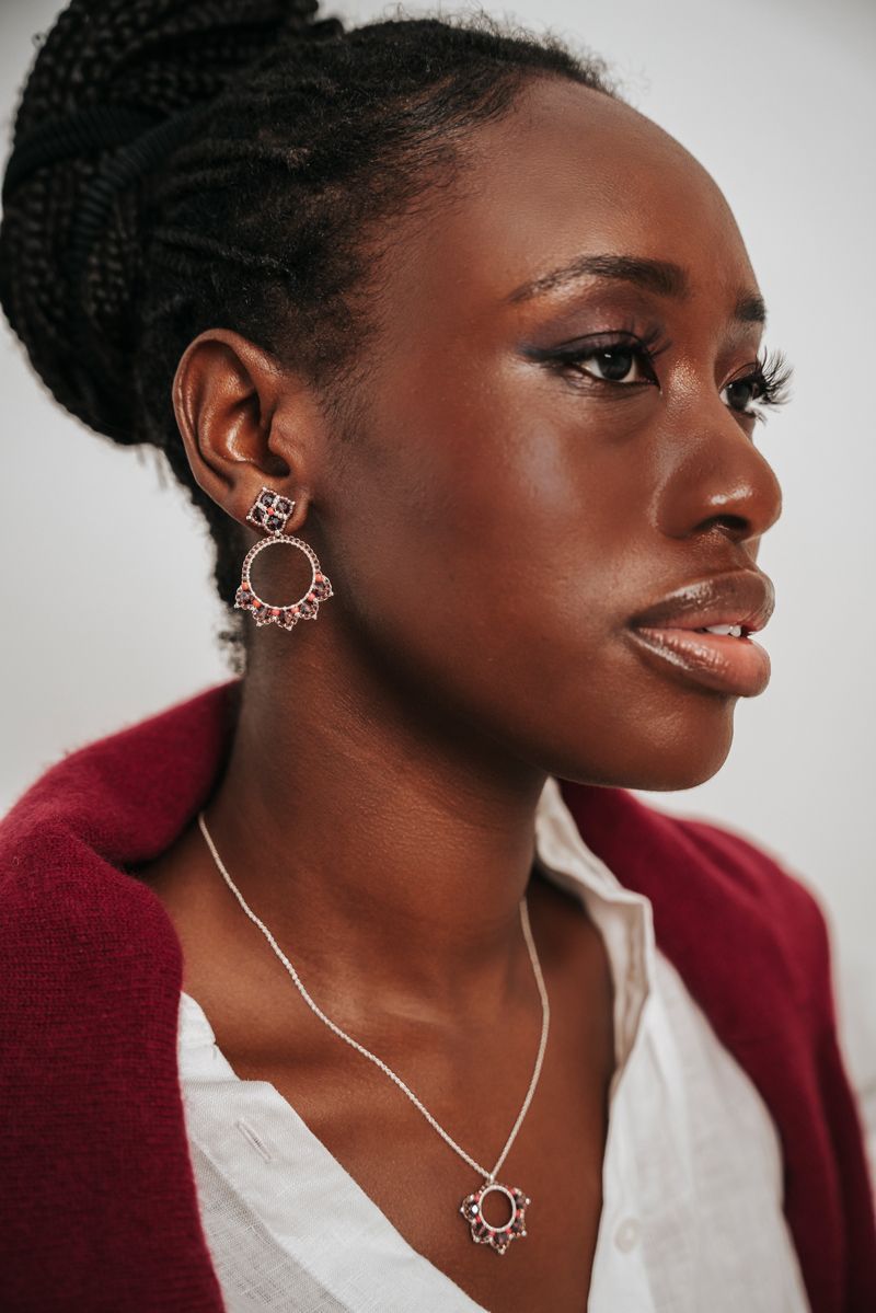 Eine Nahaufnahme einer Frau mit Ohrringen und einer Halskette