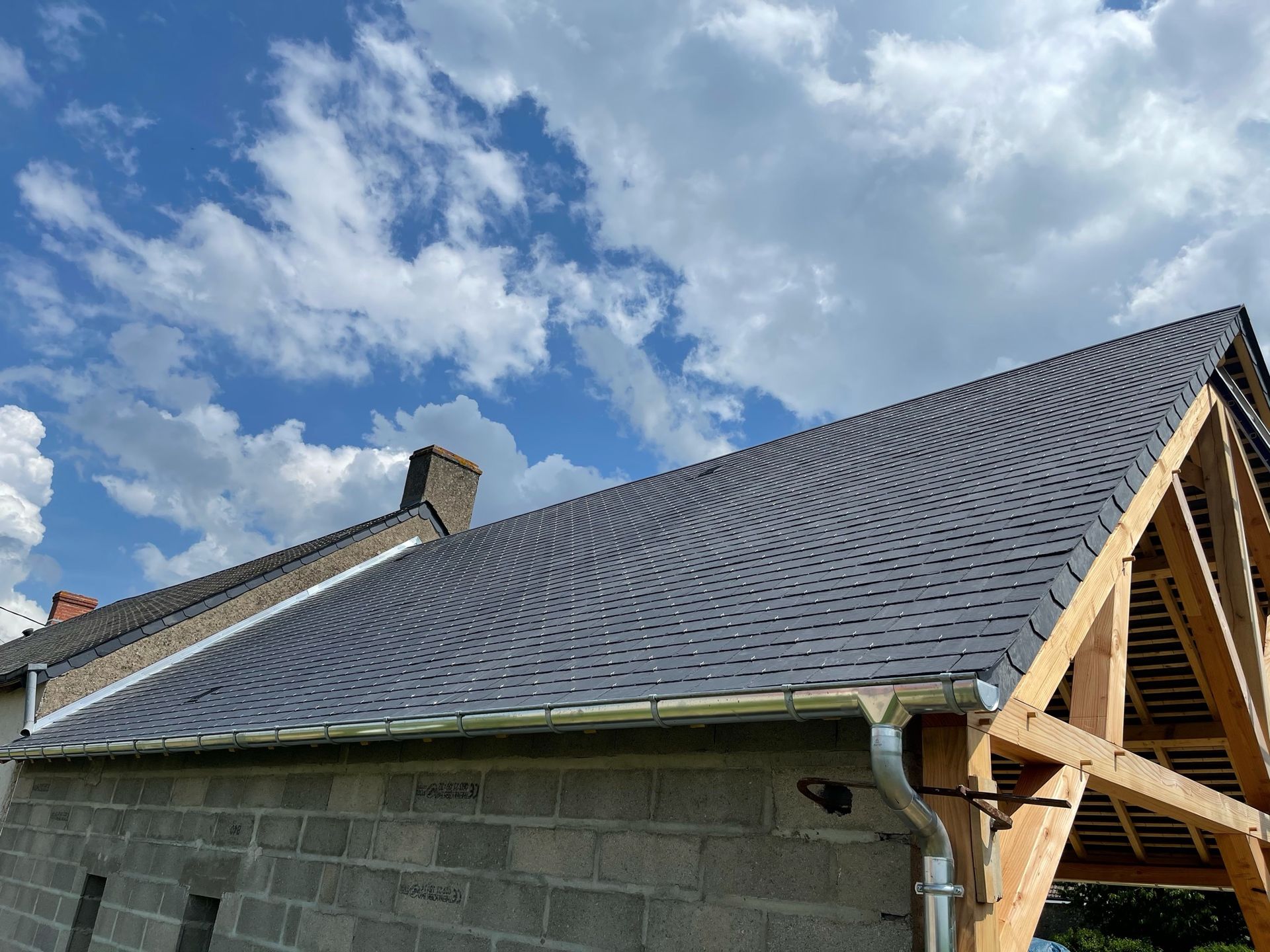 Un toit avec de l'ardoise et de la zinguerie.